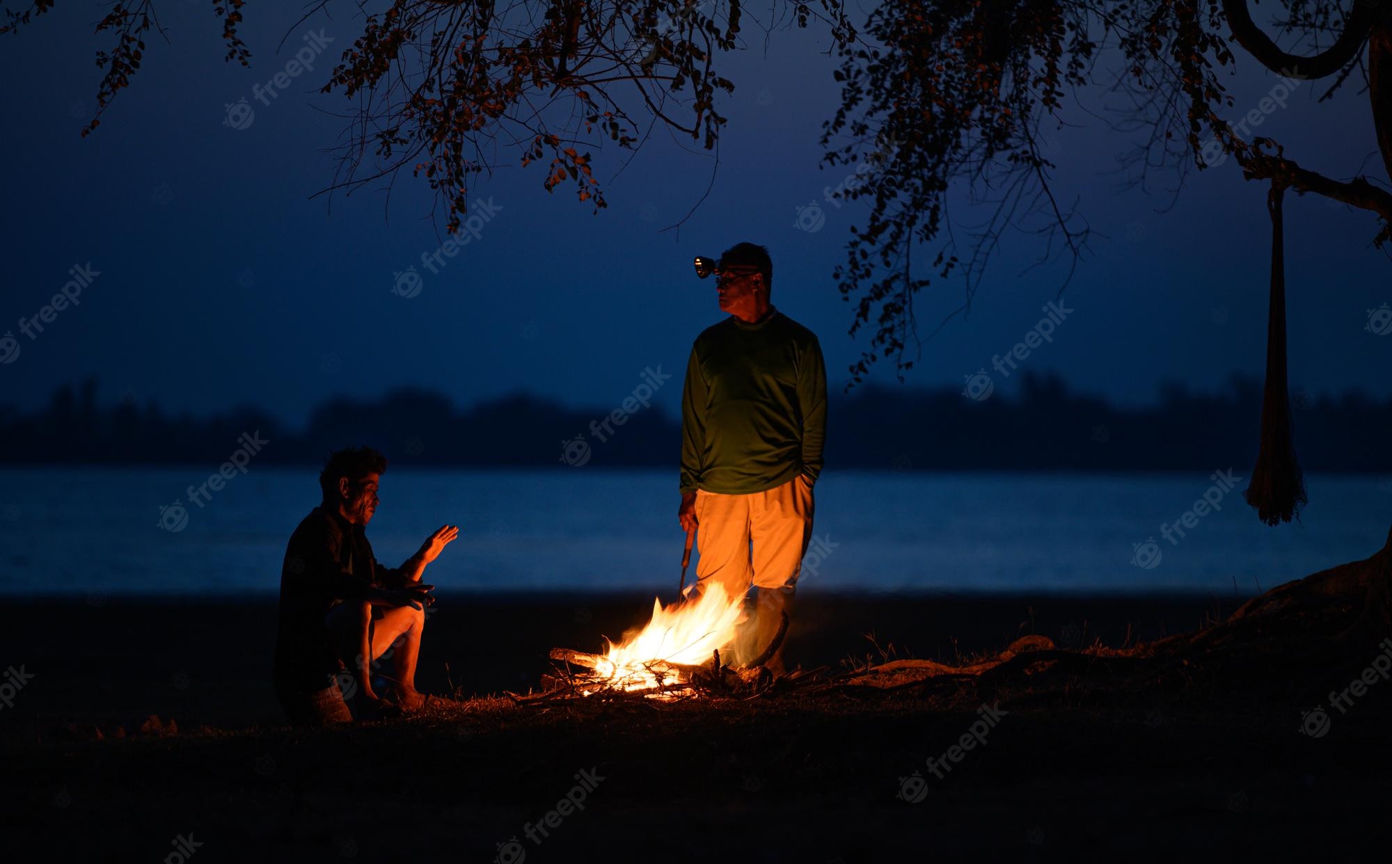 People Sitting Around Campfire In Dark Night Wallpapers