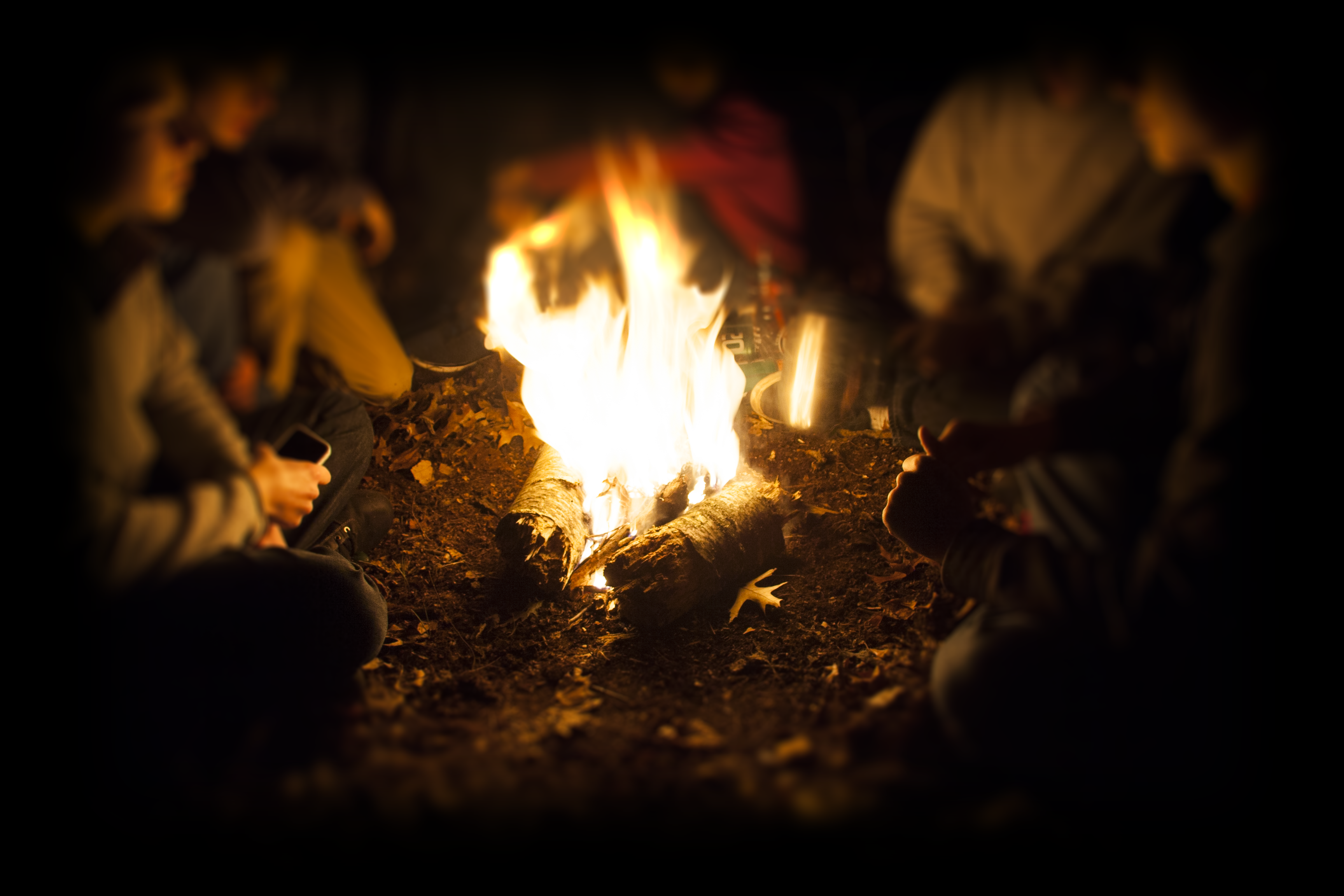 People Sitting Around Campfire In Dark Night Wallpapers