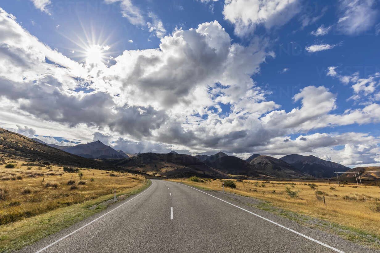 Road With Background Of Mountains And Clouds